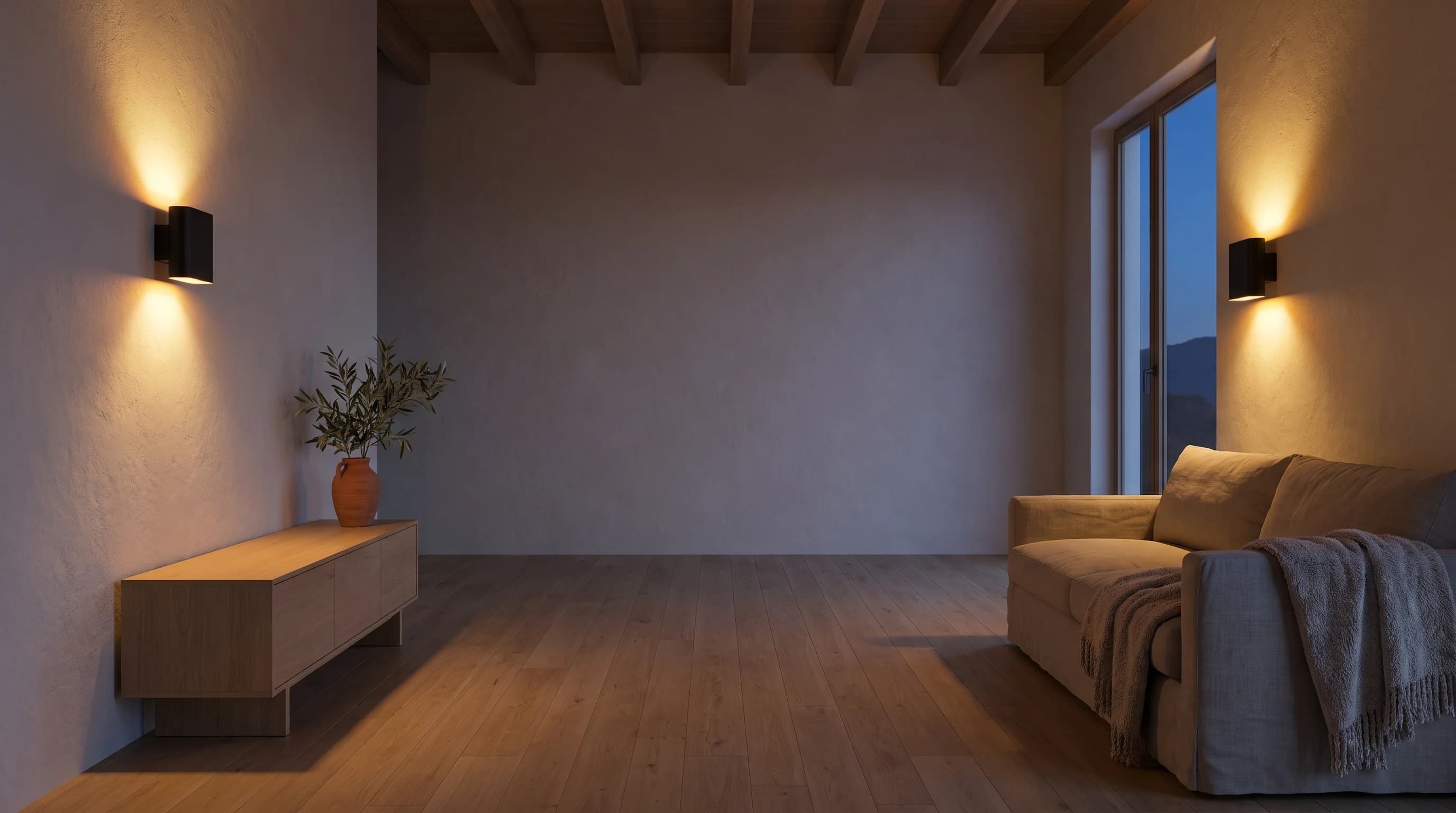 Salón al anochecer iluminado únicamente por dos apliques de pared encendidos, uno sobre la consola de roble y otro junto al ventanal